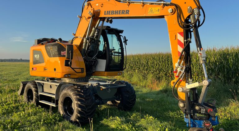 Liebherr elektrische graafmachine op een grasveld